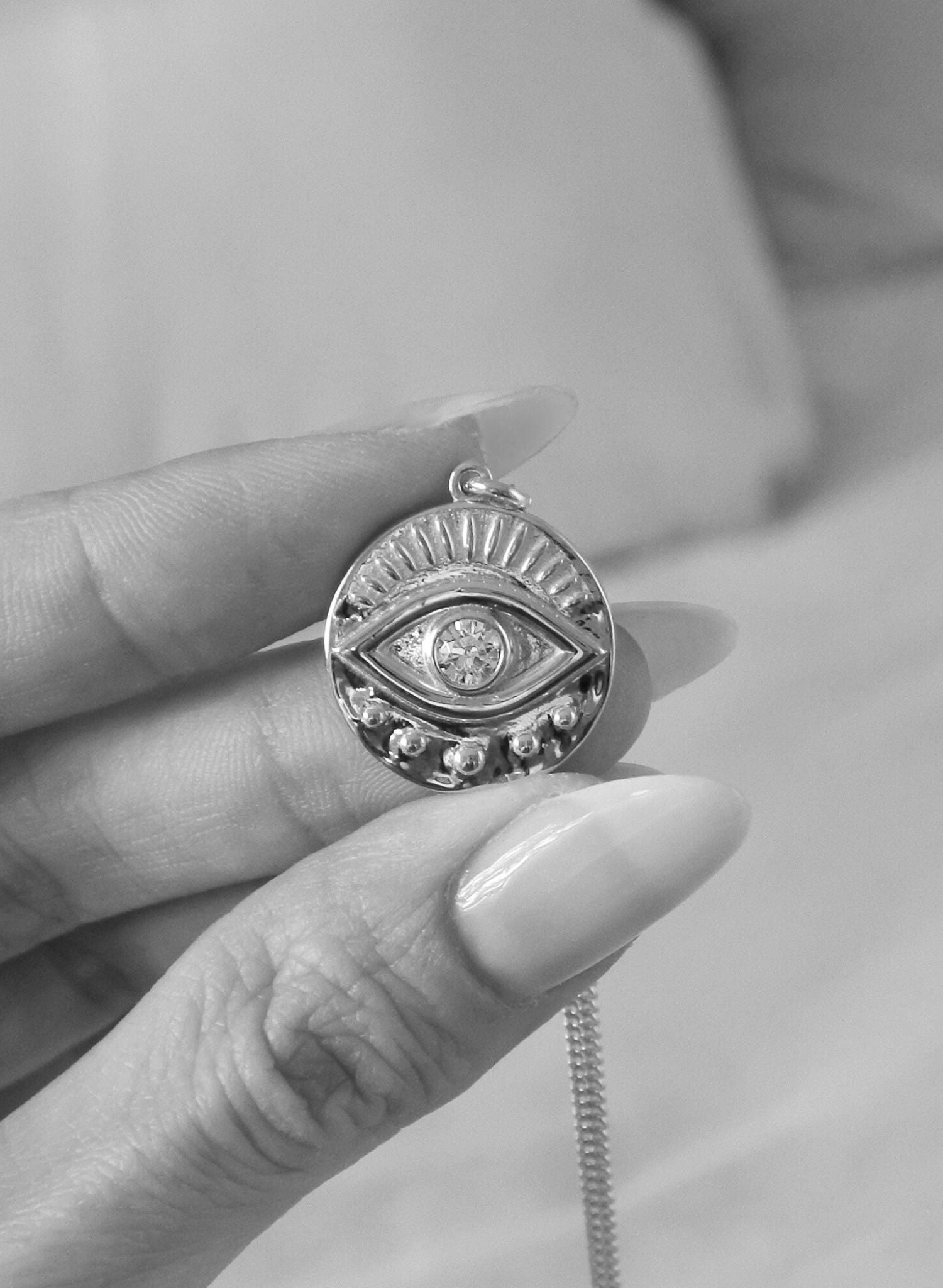 Notre collier Œil Protecteur est une incarnation moderne d'un talisman ancestral, enraciné dans les traditions qui s’étendent à travers les époques et les cultures du monde entier. Ce symbole dominé par un œil vigilant au centre représente une barrière contre les malveillances et un bouclier spirituel. Le dos du médaillon porte l'inscription "SAFE & DIVINELY PROTECTED", en français: "En sécurité et divinement protégée". Une affirmation de garde et de guidance spirituelle.