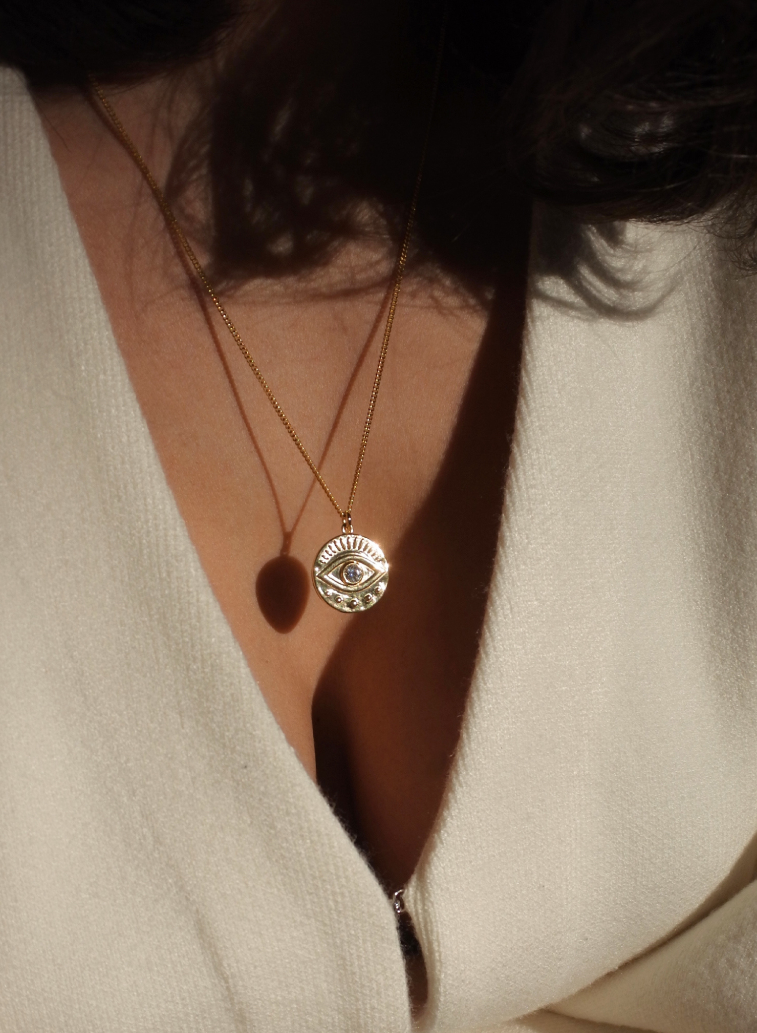 Notre collier Œil Protecteur est une incarnation moderne d'un talisman ancestral, enraciné dans les traditions qui s’étendent à travers les époques et les cultures du monde entier. Ce symbole dominé par un œil vigilant au centre représente une barrière contre les malveillances et un bouclier spirituel. Le dos du médaillon porte l'inscription "SAFE & DIVINELY PROTECTED", en français: "En sécurité et divinement protégée". Une affirmation de garde et de guidance spirituelle.