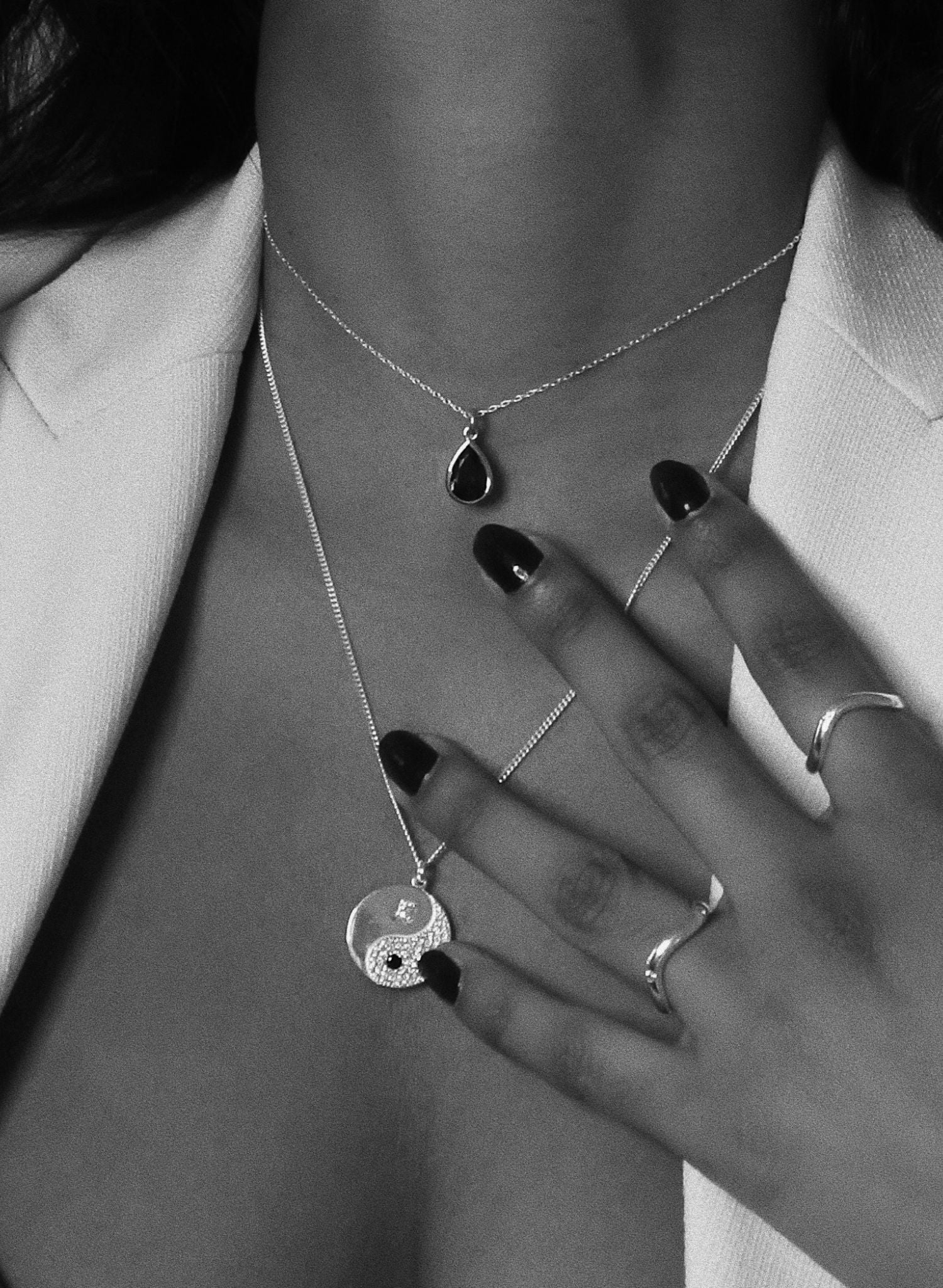 Ce bijou est une célébration de l'harmonie et de l'équilibre essentiels à une vie épanouie. Inspiré par la sagesse ancienne du Yin et du Yang, ce bijou est plus qu'un simple accessoire, c'est un symbole puissant des forces opposées mais complémentaires qui façonnent notre existence. Il nous rappelle la nature interconnectée de toutes choses ; la partie noire (yin) représente l'obscurité, le calme, la réception passive, le féminin et la douceur