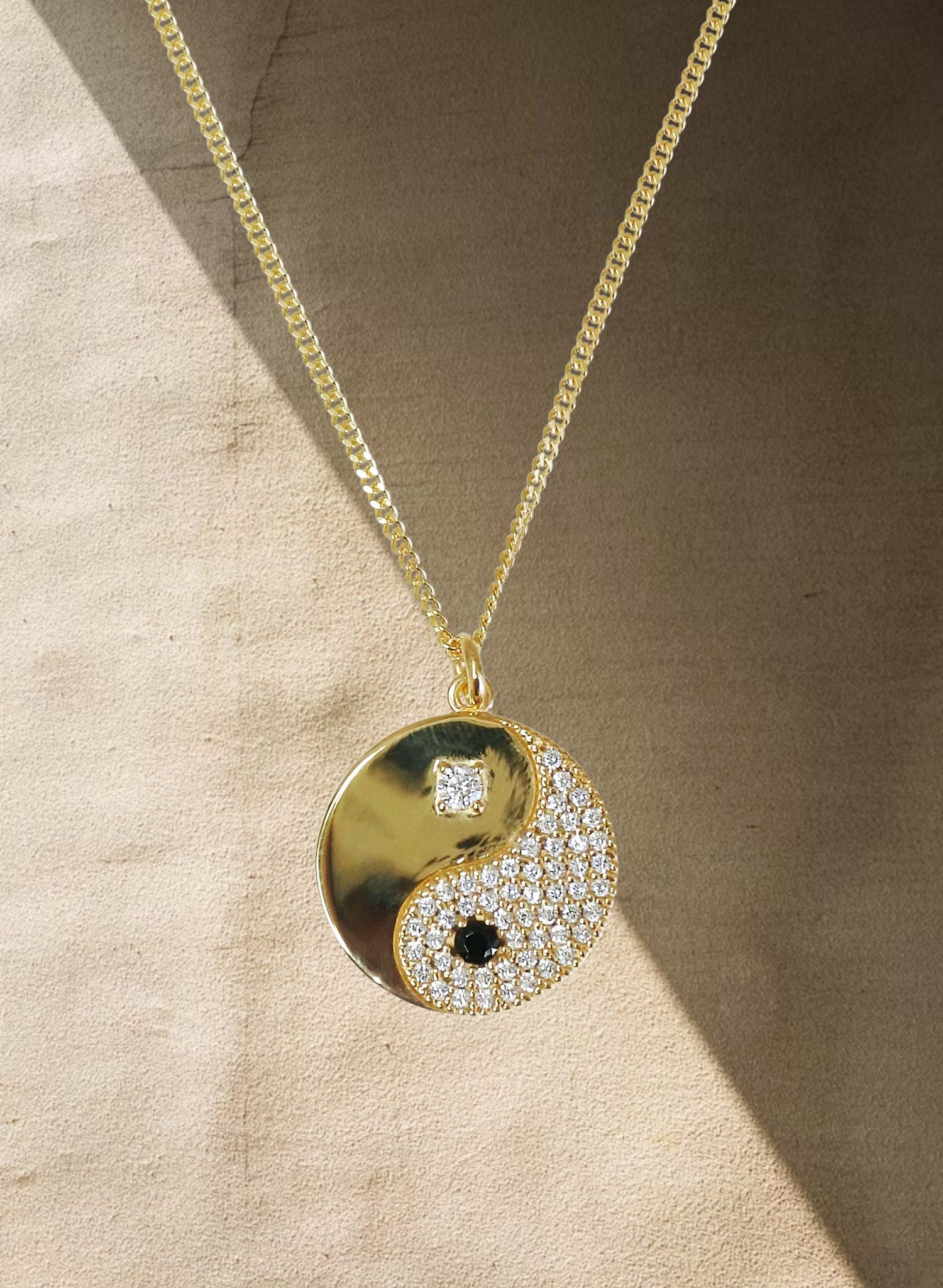 Ce bijou est une célébration de l'harmonie et de l'équilibre essentiels à une vie épanouie. Inspiré par la sagesse ancienne du Yin et du Yang, ce bijou est plus qu'un simple accessoire, c'est un symbole puissant des forces opposées mais complémentaires qui façonnent notre existence. Il nous rappelle la nature interconnectée de toutes choses ; la partie noire (yin) représente l'obscurité, le calme, la réception passive, le féminin et la douceur